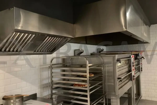 Campana mural de acero inoxidable con filtros baffle sobre horno rotatorio de panadería